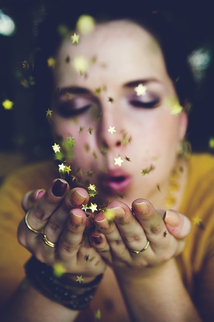 woman blowing star shaped confetti